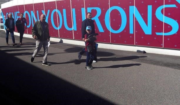 Fans arrive at the stadium ahead of the Premier League match between West Ham United and Brentford at London Stadium on October 03, 2021 in London,...