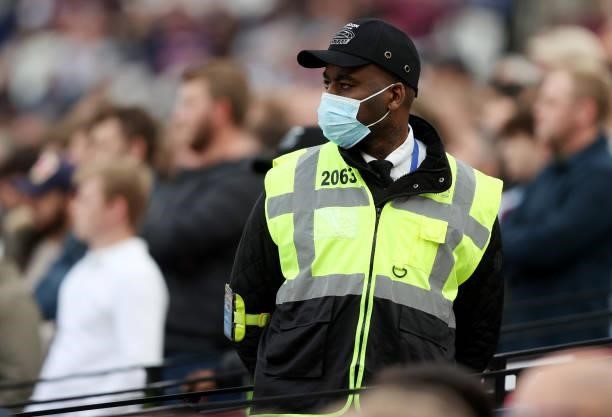View of a steward wearing a face mask during the Premier League match between West Ham United and Brentford at London Stadium on October 03, 2021 in...