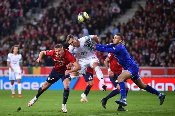Milik of Olympique de Marseille jumps for the ball between Sven Botman and Ivo Grbic of Lille OSC during the Ligue 1 Uber Eats match between Lille...