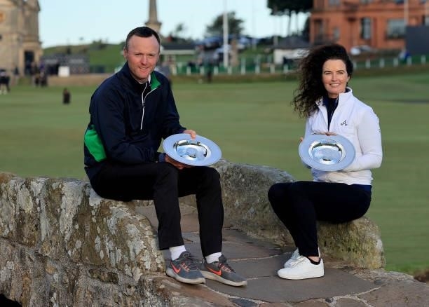 Michael Hoey of Northern Ireland and Maeve Danaher pose with the winner's team trophy on the Swilcan Bridge after the final round of The Alfred...