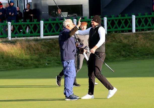 Danny Willett of England is congratulated by his amateur playing partner Jimmy Dunne on the 18th green during the final round of The Alfred Dunhill...