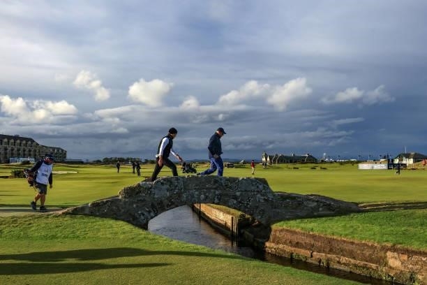 Danny Willett of England walks over the Swilcan Bridge with his amateur playing partner Jimmy Dunne on the 18th hole during the final round of The...