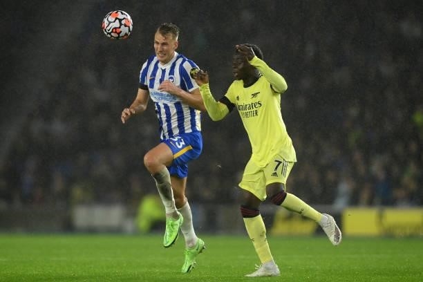 Dan Burn of Brighton & Hove Albion is challenged by Bukayo Saka of Arsenal during the Premier League match between Brighton & Hove Albion and Arsenal...