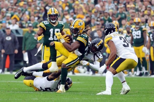 Aaron Jones of the Green Bay Packers runs the ball and is tackled by Terrell Edmunds and Devin Bush of the Pittsburgh Steelers during the second...