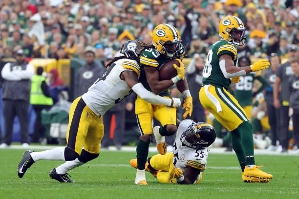 Aaron Jones of the Green Bay Packers runs the ball and is tackled by Terrell Edmunds and Devin Bush of the Pittsburgh Steelers during the second...