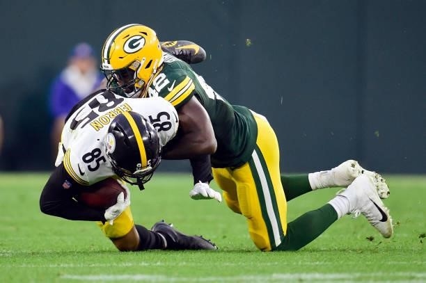 Eric Ebron of the Pittsburgh Steelers is tackled by Oren Burks of the Green Bay Packers during the second half at Lambeau Field on October 03, 2021...