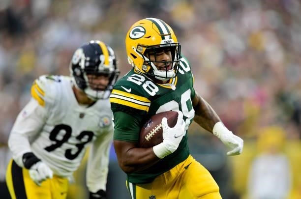 Dillon of the Green Bay Packers runs for a first down during the fourth quarter against the Pittsburgh Steelers at Lambeau Field on October 03, 2021...