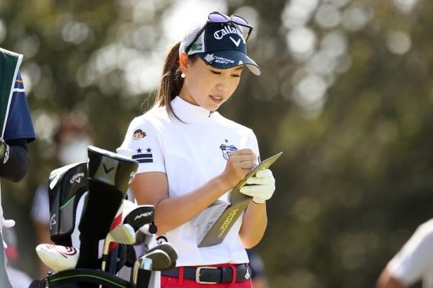 Momoko Ueda of Japan checks her yardage book on the 4th tee during the final round of the 54th Japan Women's Open Golf Championship at Karasuyamajo...