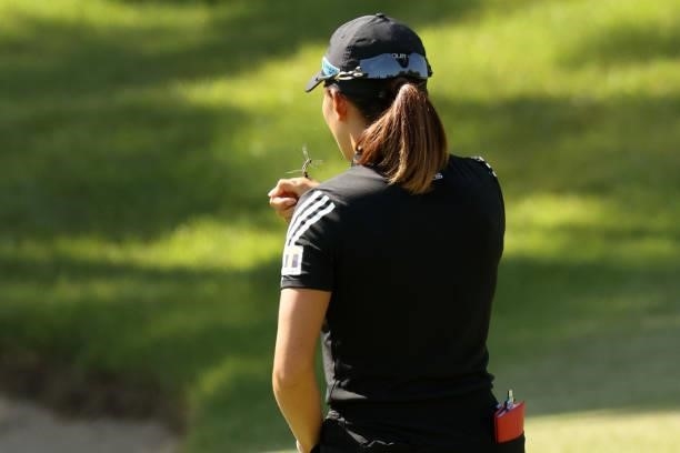 Hinako Shibuno of Japan waits as dragonflies stop on the back of the hand on the 5th hole during the final round of the 54th Japan Women's Open Golf...
