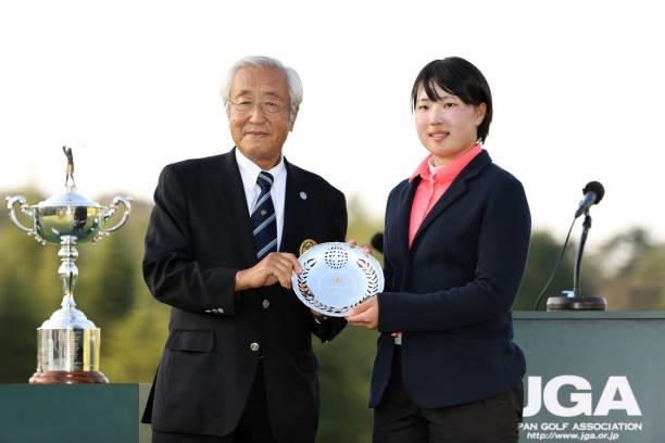 Low amateur Rio Takeda of Japan poses with Japan Golf Association CEO Tsunetada Takeda at the award ceremony following the final round of the 54th...