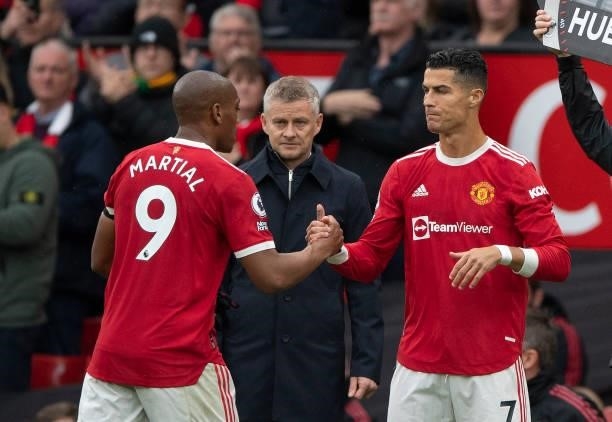 Anthony Martial of Manchester United shakes hands with Cristiano Ronaldo after being substituted as Manchester United Manager Ole Gunnar Solskjær...