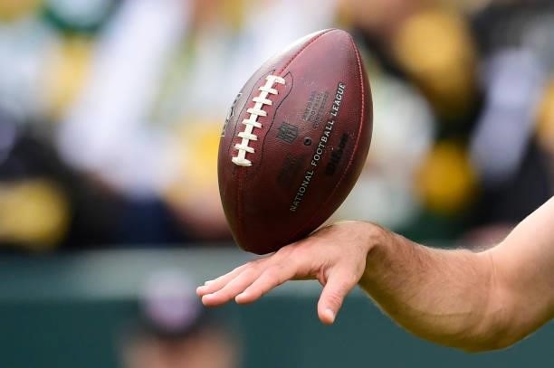 Detail view of a football on the hand of Aaron Rodgers of the Green Bay Packers during pregame against the Pittsburgh Steelers at Lambeau Field on...