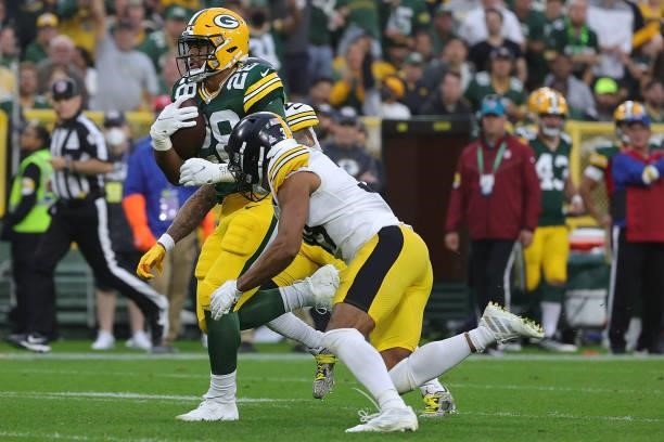 Dillon of the Green Bay Packers is brought down by Minkah Fitzpatrick of the Pittsburgh Steelers during a game at Lambeau Field on October 03, 2021...