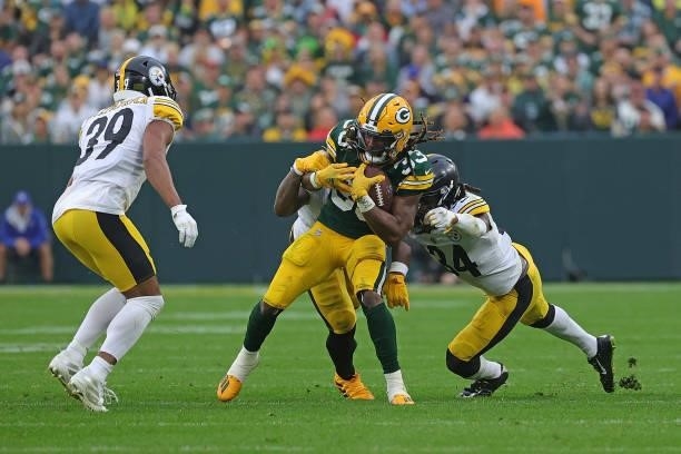 Aaron Jones of the Green Bay Packers is brought down by Terrell Edmunds of the Pittsburgh Steelers during a game at Lambeau Field on October 03, 2021...