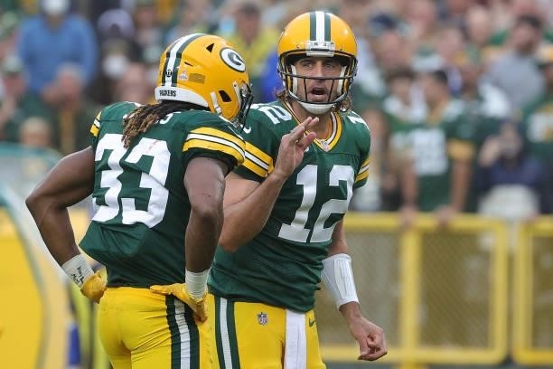 Aaron Rodgers speaks to Aaron Jones of the Green Bay Packers during a game against the Pittsburgh Steelers at Lambeau Field on October 03, 2021 in...