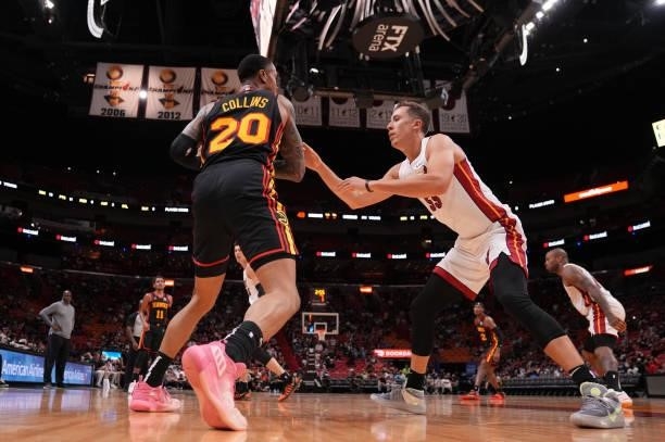 Duncan Robinson of the Miami Heat defends against John Collins of the Atlanta Hawks in the second quarter of preseason action at FTX Arena on October...