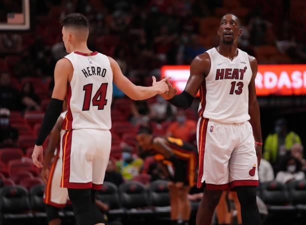 Tyler Herro and Bam Adebayo of the Miami Heat slaps hands in the second quarter against the Atlanta Hawks in preseason action at FTX Arena on October...