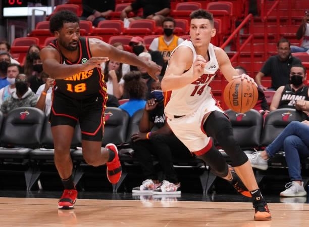 Tyler Herro of the Miami Heat drives to the basket against Solomon Hill of the Atlanta Hawks in the third quarter of preseason action at FTX Arena on...