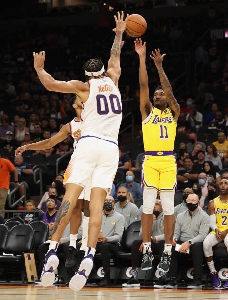 Malik Monk of the Los Angeles Lakers attempts a three-point shot over JaVale McGee of the Phoenix Suns during the first half of the NBA preseason...