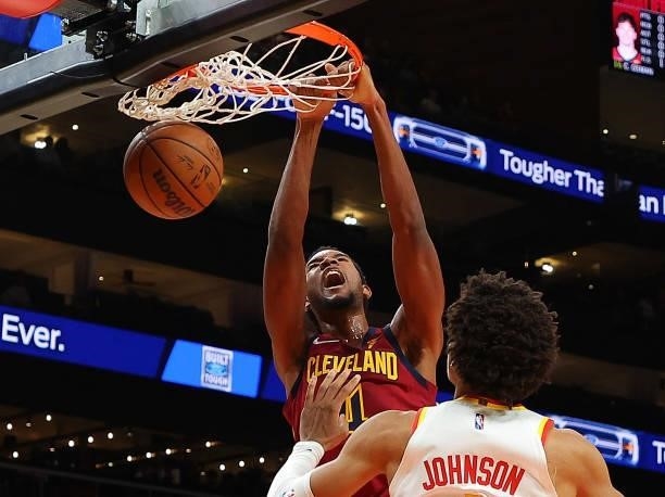 Evan Mobley of the Cleveland Cavaliers dunks against Jalen Johnson of the Atlanta Hawks during the first half at State Farm Arena on October 06, 2021...