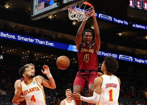 Evan Mobley of the Cleveland Cavaliers dunks against Jalen Johnson and Skylar Mays of the Atlanta Hawks during the first half at State Farm Arena on...