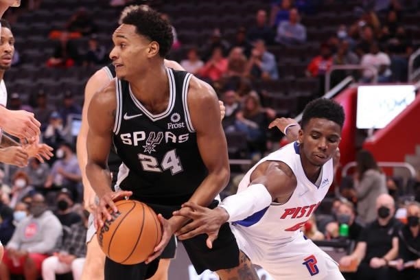 Devin Vassell of the San Antonio Spurs tries to avoid the defense of Hamidou Diallo of the Detroit Pistons during a preseason game at Little Caesars...