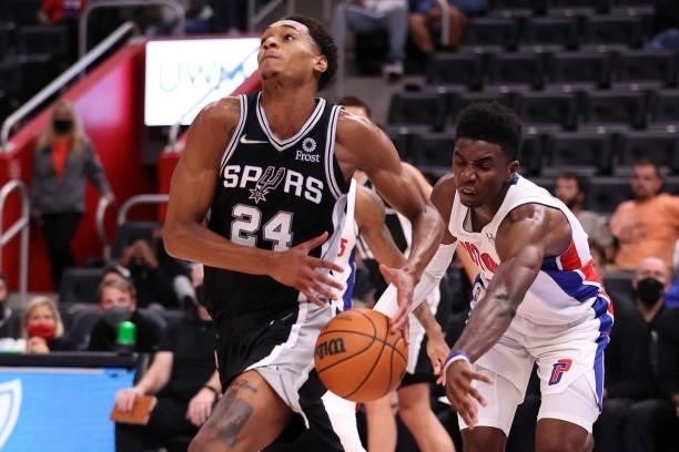 Devin Vassell of the San Antonio Spurs gets the ball knocked away by Hamidou Diallo of the Detroit Pistons during a preseason game at Little Caesars...