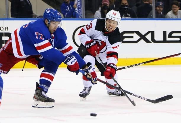 Jesper Bratt of the New Jersey Devils passes the puck past Filip Chytil of the New York Rangers during the third period during a preseason game at...