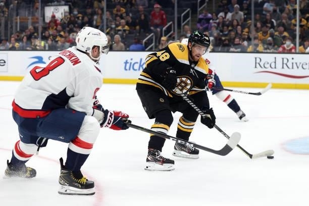 Matt Grzelcyk of the Boston Bruins skates against Alex Ovechkin of the Washington Capitals during overtime of the preseason game at TD Garden on...