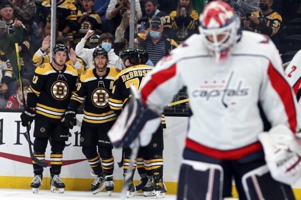 David Pastrnak of the Boston Bruins celebrates with Charlie McAvoy and Jake DeBrusk after scoring a goal against the Washington Capitals during the...