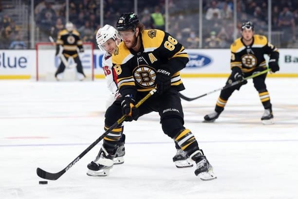 Nic Dowd of the Washington Capitals defends David Pastrnak of the Boston Bruins during the first period of the preseason game at TD Garden on October...