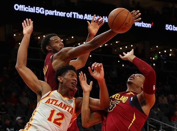 De'Andre Hunter of the Atlanta Hawks battles for a rebound against Evan Mobley and Isaac Okoro of the Cleveland Cavaliers during the second half at...