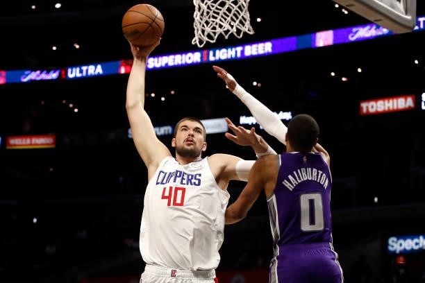 Ivica Zubac of the Los Angeles Clippers attempts a dunk against Tyrese Haliburton of the Sacramento Kings during the first quarter of the preseason...