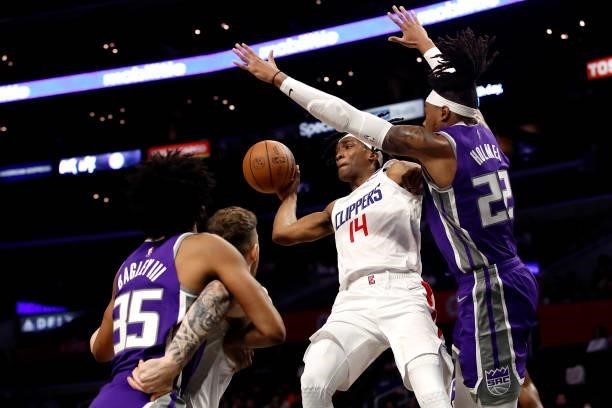 Terance Mann of the Los Angeles Clippers passes the ball against Richaun Holmes of the Sacramento Kings during the first quarter of the preseason...