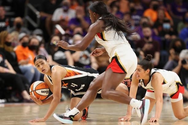 Skylar Diggins-Smith of the Phoenix Mercury attempts to control the ball ahead of Kelsey Plum and Jackie Young of the Las Vegas Aces during the first...