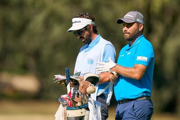 Romain Langasque of France studies his shot together his caddie during Day One of The Acciona Open de Espana at Club de Campo Villa de Madrid on...