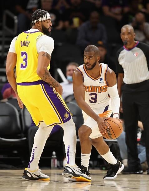 Chris Paul of the Phoenix Suns handles the ball against Anthony Davis of the Los Angeles Lakers during the NBA preseason game at Footprint Center on...