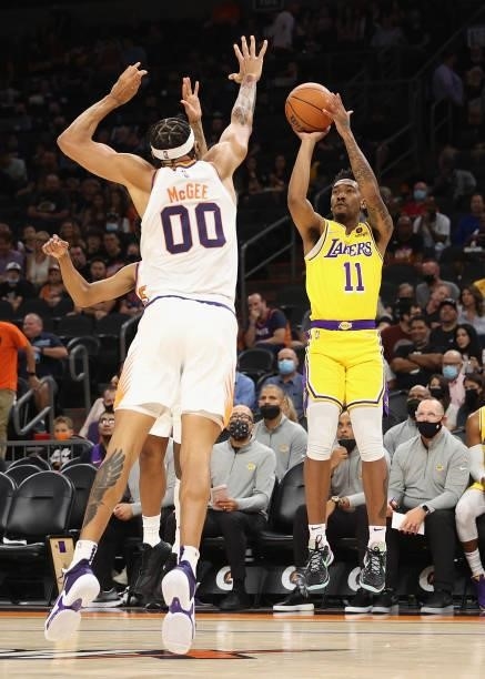 Malik Monk of the Los Angeles Lakers shoots the ball over JaVale McGee of the Phoenix Suns during the NBA preseason game at Footprint Center on...