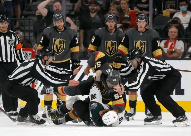 Keegan Kolesar of the Vegas Golden Knights and Liam O'Brien of the Arizona Coyotes fight in the second period of their preseason game as linesmen...