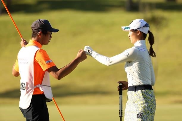 Rei Matsuda of Japan fist bumps with her caddie after the bridie on the 8th green during the first round of the Stanley Ladies at Tomei Country Club...