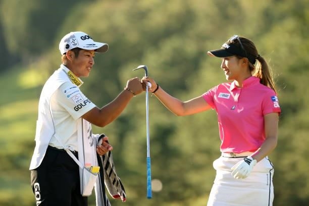Reika Usui of Japan fist bumps with her caddie after the birdie on the 8th green during the first round of the Stanley Ladies at Tomei Country Club...