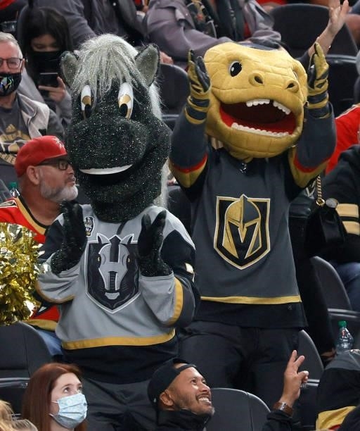 The Henderson Silver Knights mascot Lucky and the Vegas Golden Knights mascot Chance the Golden Gila Monster cheer in the stands during a preseason...