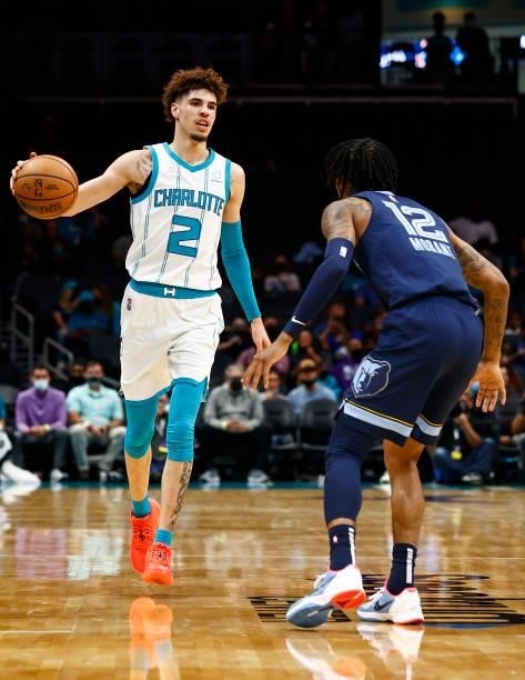 LaMelo Ball of the Charlotte Hornets brings the ball up court against Ja Morant of the Memphis Grizzlies during the first period of their game at...