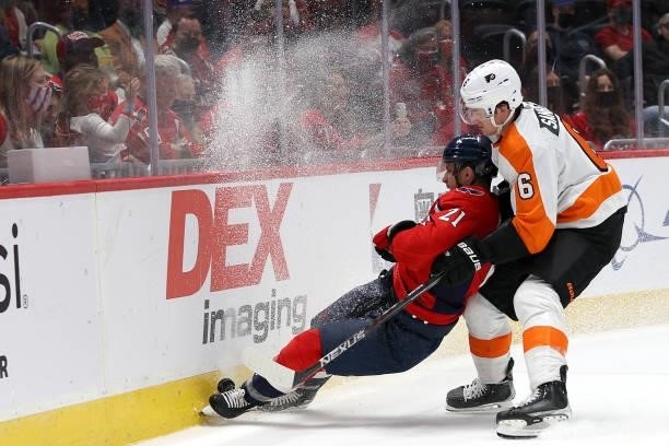 Travis Sanheim of the Philadelphia Flyers and of the Washington Capitals go after the puck in the second of a preseason game at Capital One Arena on...