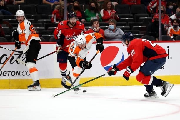 Cam Atkinson of the Philadelphia Flyers passes the puck in front of Lars Eller of the Washington Capitals in the second period during a preseason...