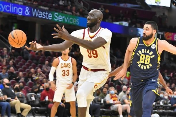 Tacko Fall of the Cleveland Cavaliers loses the ball as he drives to the basket while under pressure from Goga Bitadze of the Indiana Pacers at...
