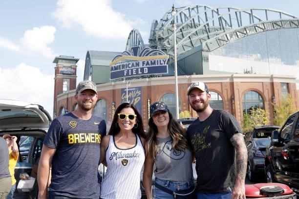 Milwaukee Brewers fans pose while tailgating before Game One of the National League division series between the Atlanta Braves and the Milwaukee...