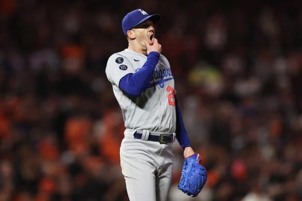 Walker Buehler of the Los Angeles Dodgers reacts after allowing a single by Tommy La Stella of the San Francisco Giants during the third inning of...