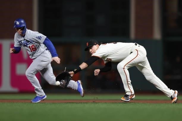 Wilmer Flores of the San Francisco Giants makes a diving catch and throws out Will Smith of the Los Angeles Dodgers on a fielder's choice during the...