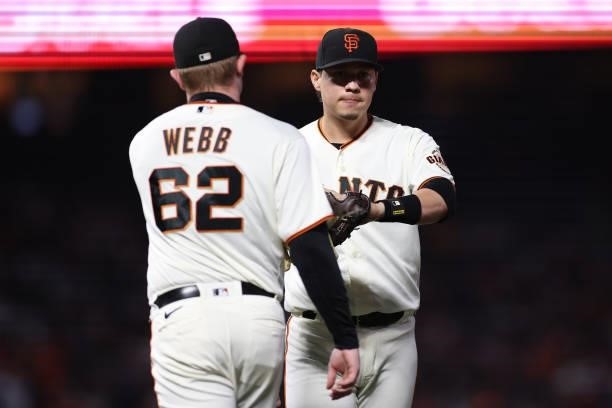 Wilmer Flores and Logan Webb of the San Francisco Giants celebrate against the Los Angeles Dodgers during the fifth inning of Game 1 of the National...